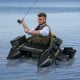 Portable fishing boat in green with detachable storage boxes, designed for comfort and equipped for fishing gear.