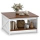 Square farmhouse coffee table with a white finish, featuring a storage shelf and decorative items on top.
