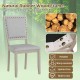 Farmhouse dining chair with grey fabric upholstery, rubber wood frame, and vintage nailheads for rustic elegance.