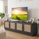 Farmhouse TV stand in black showcases a wide tabletop and elegant rattan doors, ideal for stylish living room organization.