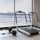 Folding treadmill with LED display and dumbbell weight set, ideal for versatile home workouts in a fitness room.