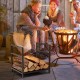 Firewood log rack in black with raised feet and handles, ideal for keeping logs dry and organized by the fire.