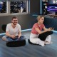 Two individuals enjoying gaming on a gray floor comfy leisure chair with adjustable headrest and backrest.