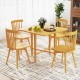 Foldable dining table with rubber wood legs, featuring drop leaf design, set for four in a cozy indoor setting.