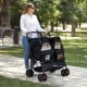 Foldable double pet stroller in black with adjustable sunshade, featuring two mesh compartments for pets and storage.