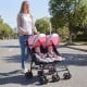 Twin baby stroller in pink, featuring an umbrella fold design, 360-degree swivel wheels, and a lightweight frame for.