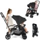 Foldable twin tandem stroller in black with adjustable handlebar, reclining front seat, and ample storage for kids.