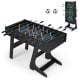 Folding foosball table in black with 22 players, slide scorers, and realistic soccer field graphics for family fun.