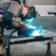 Folding welding table with adjustable height, tiltable tabletop, and tool slots, ideal for efficient welding work.