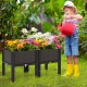 Elevated plastic raised garden bed planter kit with flowers, featuring a stylish rattan design for outdoor gardening.
