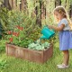Rectangular brown planter box made of fir wood, featuring drainage holes, filled with plants in a backyard garden.