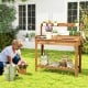 Outdoor wooden garden table work station with storage shelves, drawer, and removable sink for gardening tasks.