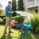 Garden hose reel cart in blue with 2 wheels, storage basket, and foam-padded handrail for easy maneuvering in the.