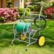Garden hose reel cart with two wheels, storage basket, and durable metal frame for easy maneuvering in the garden.