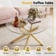 Round glass coffee table with a golden geometric frame, featuring a tempered glass top for modern aesthetics and easy.