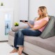 Adjustable gray memory foam reading sleep back support pillow on a sofa, providing ergonomic comfort for relaxation.