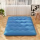 Blue foldable futon mattress with washable cover, ideal for camping or as a floor mat, shown in a cozy indoor setting.