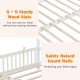 Close-up of sturdy wood slats and safety raised guard rails on a white extendable house bed for kids' safety.