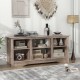 Gray TV stand with adjustable shelves, designed for up to 65-inch TVs, perfect for storage and modern home aesthetics.