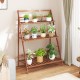 3-tier brown bamboo ladder shelf with plants, ideal for indoor or outdoor use as a display stand or storage rack.