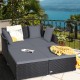 Spacious outdoor rattan daybed with gray upholstered cushions, perfect for relaxation on patios or balconies.