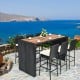 7-piece patio rattan wicker dining set with a wooden table and bar stools, perfect for outdoor dining by the sea.