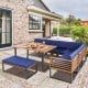 Patio dining set featuring acacia wood table and navy cushions, perfect for outdoor relaxation in backyard or poolside.