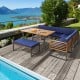 Patio dining set featuring acacia wood table and navy cushions, ideal for outdoor relaxation by the poolside.