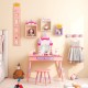 Kids princess vanity table and stool set in pink with a castle theme, featuring a mirror and large drawer for.