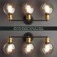 Modern 3-light bubbled glass vanity light showcasing elegant golden sockets and black iron frame, ideal for versatile.