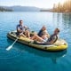 Three people enjoying the Heavy-Duty Inflatable Boat in a serene lake, perfect for fishing trips and family outings.