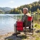 Heavy-duty outdoor camping chair in red with cup holder and side pocket, perfect for fishing and relaxation by the lake.