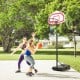 Height adjustable basketball hoop in action with players, showcasing its sturdy fillable base and weather-resistant.