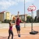 Height adjustable basketball hoop with shatterproof backboard and fillable base, ideal for outdoor play and stability.