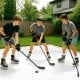 Three young players practicing hockey on synthetic ice tiles, featuring a self-lubricating surface for realistic.