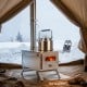 Portable wood burning stove with stainless steel construction, adjustable chimney, and flat top for outdoor cooking.
