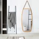 Elegant bamboo-framed wall mirror with adjustable leather strap, ideal for enhancing any space's decor and visual.