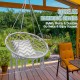 Hanging macrame hammock chair in gray with cotton backrest, ideal for indoor or outdoor relaxation and meditation.