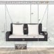 2-person patio rattan porch swing with white cushions, featuring sturdy steel chains for secure outdoor relaxation.