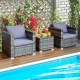 Patio rattan sofa set with gray cushions, featuring a coffee table, perfect for outdoor relaxation by the poolside.
