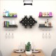 Wall-mounted black wine rack set with storage shelves, holding eight bottles and displaying glasses and decor items.