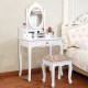 Vanity makeup dressing table in white with rotating mirror, three drawers, and cushioned stool for elegant beauty.