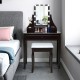 Brown cushioned stool beside the elegant vanity table with a 10 LED lighted mirror and 3 spacious drawers for cosmetics.