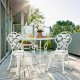 White outdoor cast aluminum patio bistro set with rose design, perfect for balcony or garden relaxation.