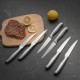 14-piece stainless steel kitchen knife set displayed on a cutting board with steak and lemon, featuring ergonomic.