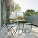 Two folding bistro chairs with blue floral mosaic pattern on a patio, perfect for outdoor relaxation and dining.