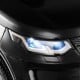 Close-up of the black 12V kids ride-on car's LED headlights, featuring a realistic design and remote control.