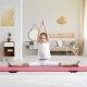 Child performing a split on a pink 9 FT folding gymnastics balance beam with a pine wood frame in a bright living room.