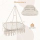 Hand-woven rope hanging chair in beige with thick cushion, featuring elegant tassels and a sturdy folding metal frame.