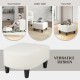 Beige ottoman with black legs, made of teddy velvet, used as a footrest or extra seat for versatile living room decor.